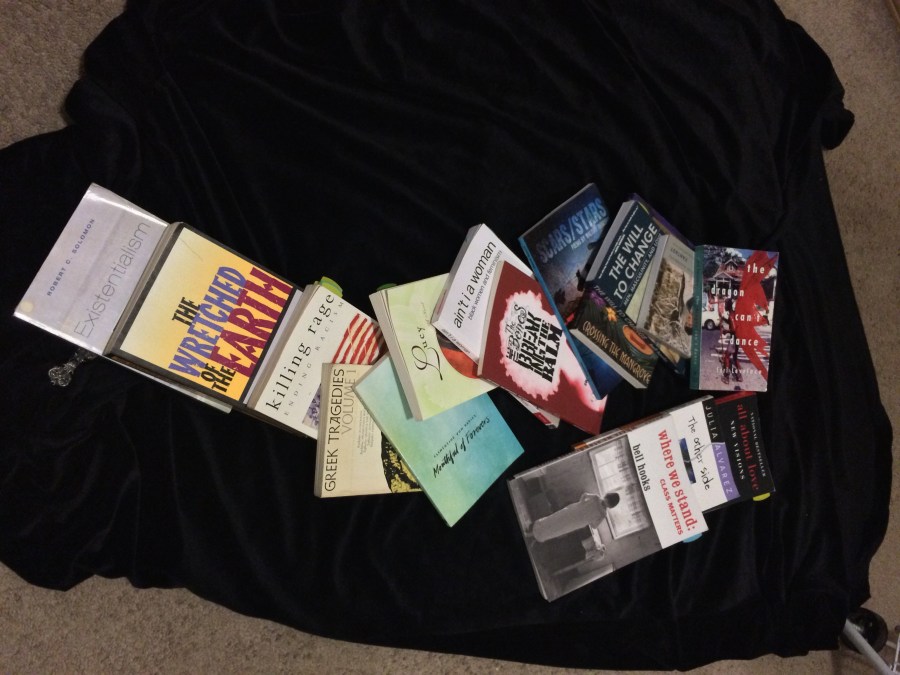 photo of a large number of books spread out on a black velveteen cloak